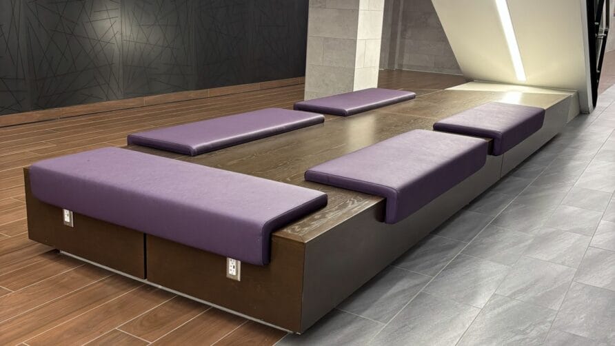 Modern seating with purple cushions in a contemporary interior space, featuring wood and sleek architectural design.