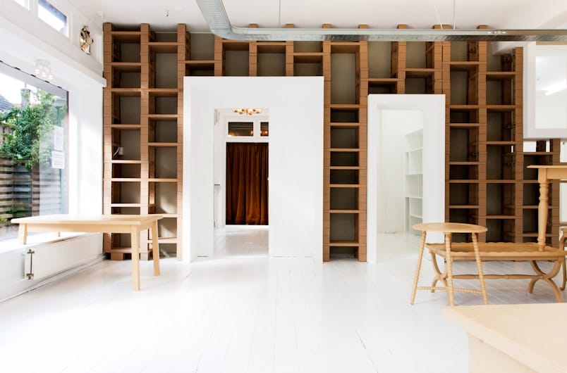 White room lined with floor-to-ceiling wood shelving